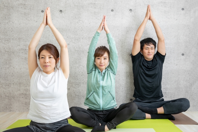 イベントヨガでヨガマットに座ってポーズをとる三人
